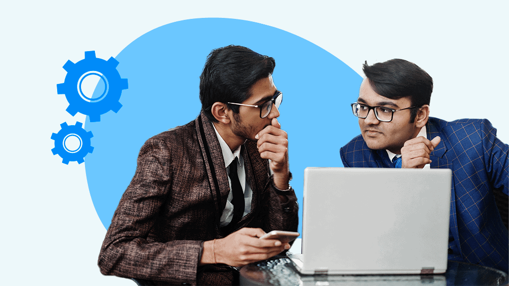 Two men in discussion in front of a laptop computer